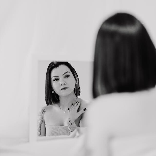 mujer se mira al espejo