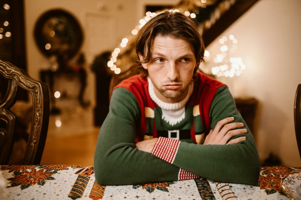 hombre joven con cara de desagrado vestido de navidad