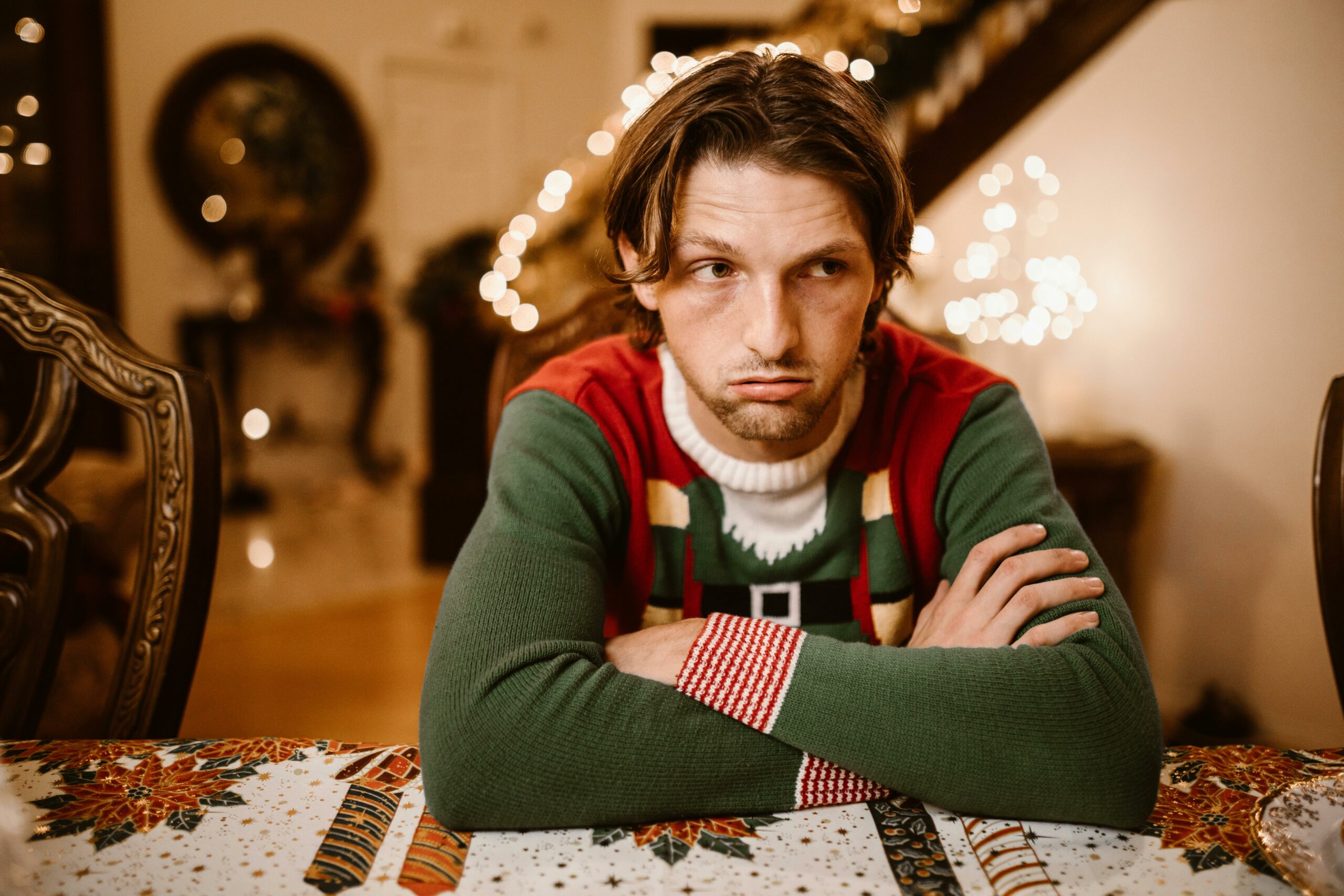 hombre joven con cara de desagrado vestido de navidad